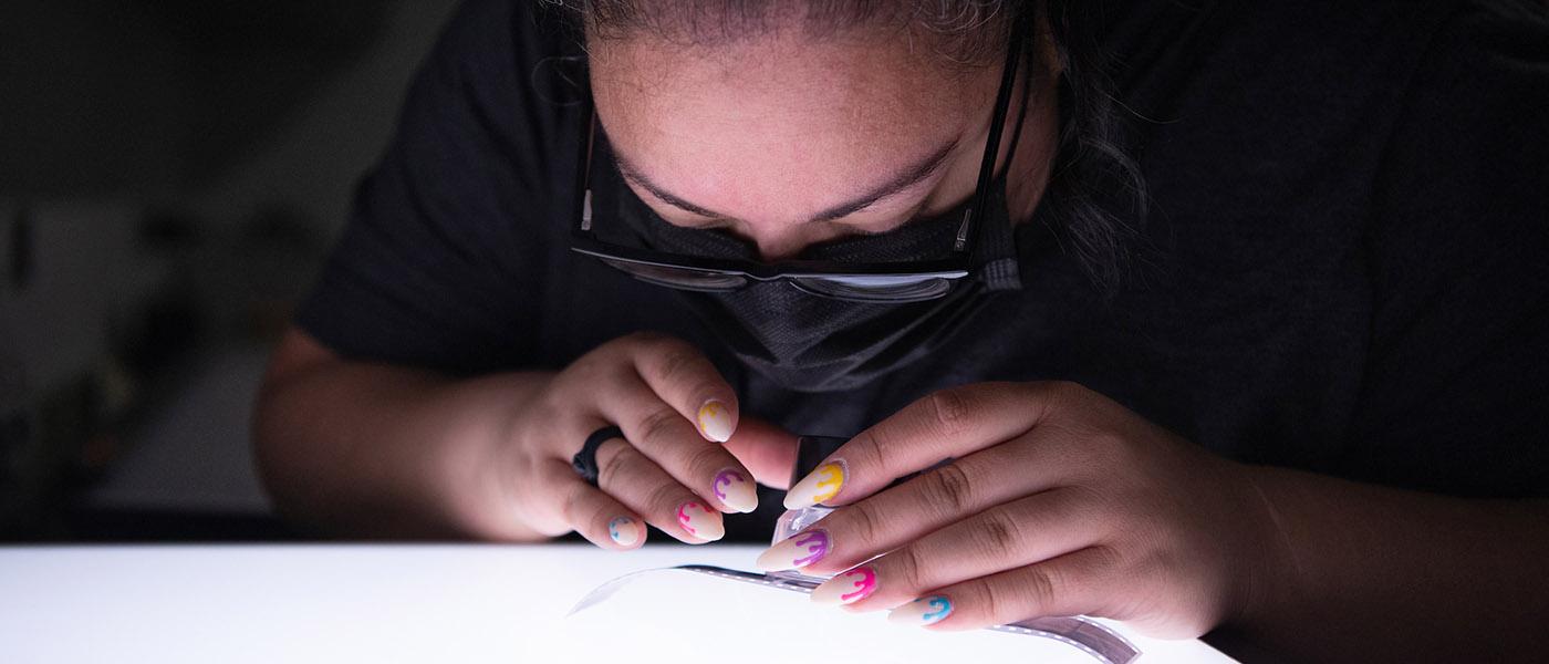 Photography student analyzing film negatives using a lightbox